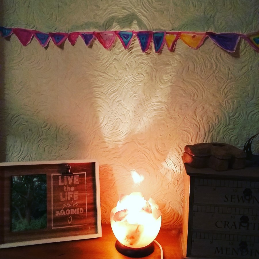 Image of a Himalayan rock salt lamp, a picture frame that says "Live the Live You've Imagined" and handmade paper bunting on the wall. #WitchyWednesday Lammas Blessings SpookyMrsGreen.com mindful parenting and modern pagan lifestyle blog.