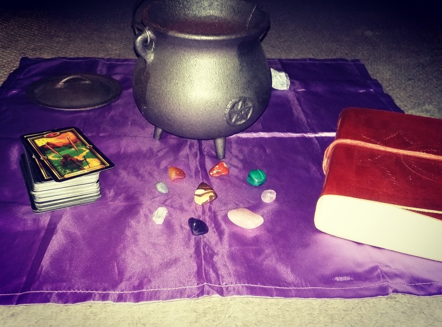 Image of Tarot cards, assorted crystals, a book of shadows and a witch's cauldron. Cauldron Magic with vampire writer Catherine Green at SpookyMrsGreen.com mindful parenting and modern pagan lifestyle blog.