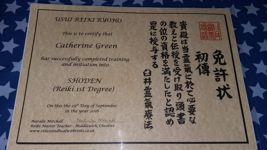 Photo of a certificate for Catherine Green qualifying as a Usui Reiki Ryoho Shoden Reiki First Degree reiki practitioner.