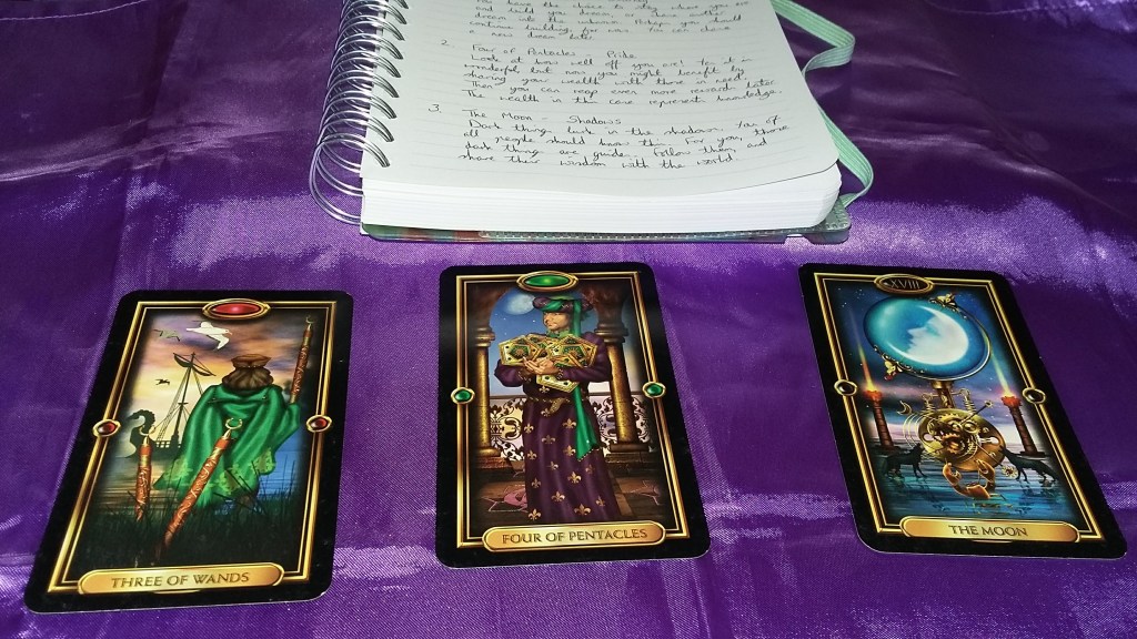 Photo of Gilded Tarot cards and Tarot reading notebook on a purple cloth. #365DaysofTarot Tarot reading with Gilded Tarot card deck owned by professional Tarot reader Catherine Green of SpookyMrsGreen.com pagan lifestyle blog.