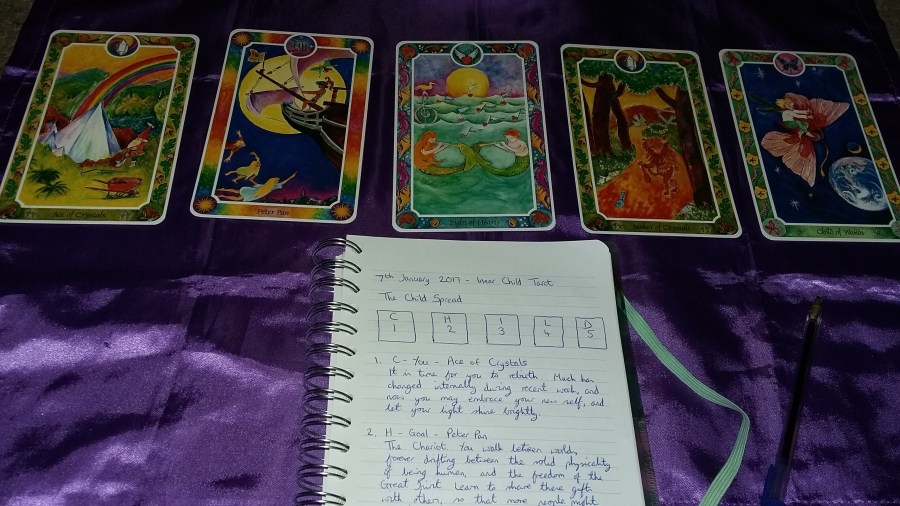 Image of Inner Child fairytale Tarot cards and Tarot notebook on a purple cloth. #365DaysofTarot Tarot reading with Inner Child Tarot card deck owned by professional Tarot reader Catherine Green of SpookyMrsGreen.com pagan lifestyle blog.