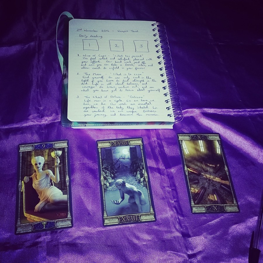 Image of Vampires Tarot of the Eternal Night Tarot cards and Tarot notebook on a purple cloth. #365DaysofTarot Daily Tarot reading with Vampires Tarot of the Eternal Night Tarot card deck owned by professional Tarot reader Catherine Green of SpookyMrsGreen.com pagan lifestyle blog.