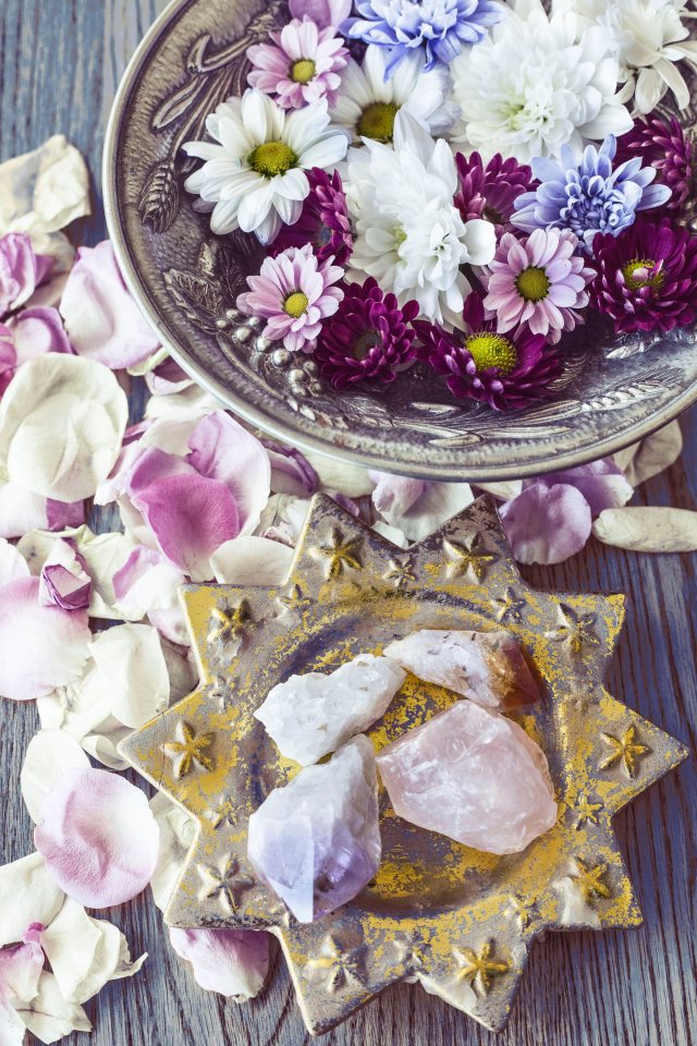 Image of amethyst crystal, rose quartz crystal, clear quartz crystal and white crystal in a decorative dish surrounded by flower petals and a bowl of flowers. Crystals for Strength by NEJ Photography based in Hereford and the local area featured at SpookyMrsGreen.com mindful parenting and modern pagan lifestyle blog.