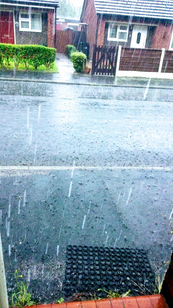 Image of heavy rain on a small suburban street in England. Storm Ali (Poem) written by poet Catherine Green for SpookyMrsGren.com mindful parenting and modern pagan lifestyle blog.