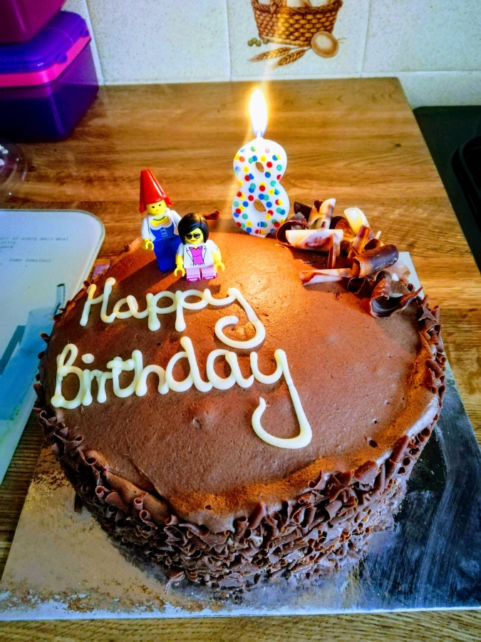 Image of a homemade chocolate birthday cake with LEGO minifigures and number 8 candle made by Catherine Green. #MummyMonday Celebrating Birthday Week article by Catherine Green SpookyMrsGreen.com mindful parenting and modern pagan lifestyle blog.