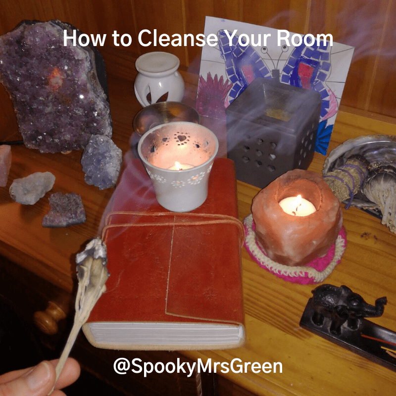 Image of a Book of Shadows, Amethyst crystal lamp, white sage smudge stick, pink rock salt candle holder, assorted crystals and candles. Text reads "How to Cleanse Your Room @SpookyMrsGreen." #WitchyWednesday How to Cleanse Your Room article by SpookyMrsGreen.com mindful parenting and modern pagan lifestyle blog.