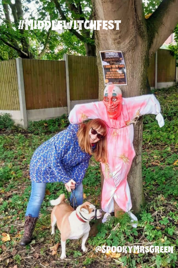 Image of Catherine Green with her dog, Marley standing next to a scary clown scarecrow in Middlewich, Cheshire, England. #WitchyWednesday #Middlewitchfest Halloween celebrations with SpookyMrsGreen.com mindful parenting and modern pagan lifestyle blog.