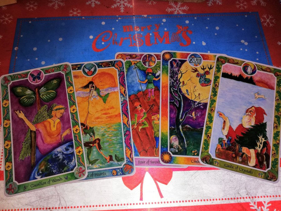 Image of Inner Child (Fairytale) Tarot cards on a placemat that says "Merry Christmas." Christmas Tarot Reading by professional Tarot reader Catherine Green of SpookyMrsGreen.com pagan lifestyle blog.