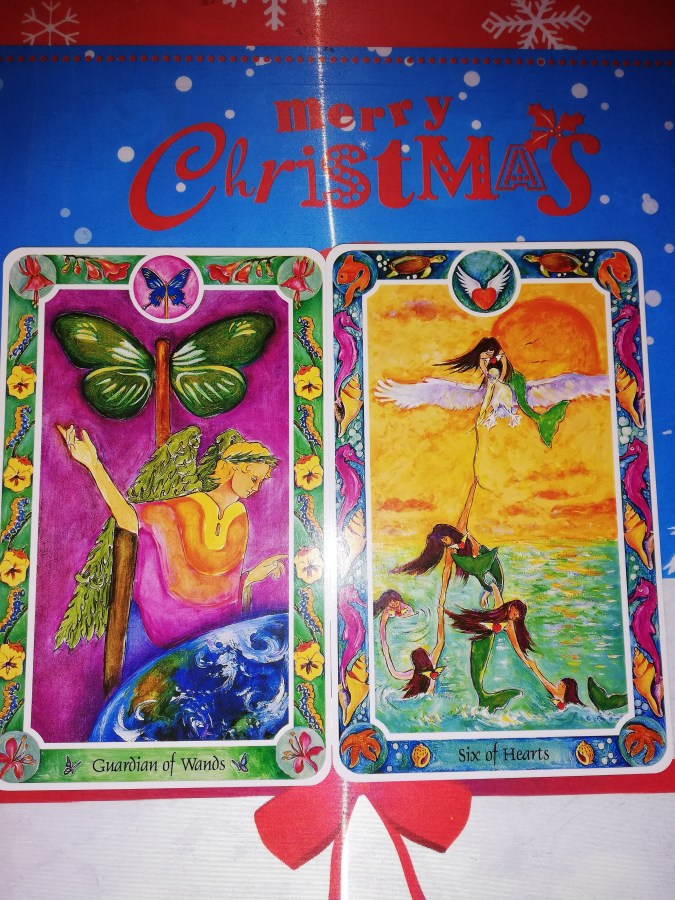 Image of Inner Child (Fairytale) Tarot cards on a placemat that says "Merry Christmas." Christmas Tarot Reading by professional Tarot reader Catherine Green of SpookyMrsGreen.com pagan lifestyle blog.