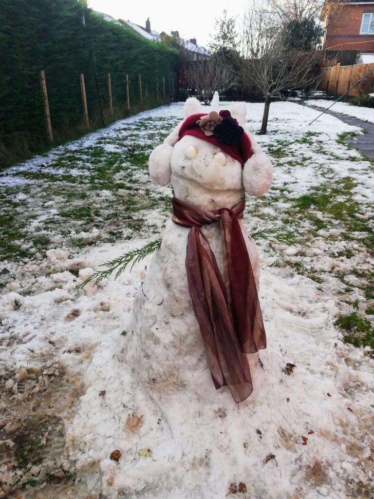 Snowman wearing scarf, hat and earmuffs in our garden at SpookyMrsGreen.com mindful parenting and modern pagan lifestyle blog.