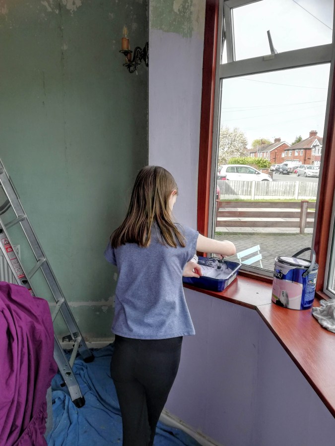 Image of a girl painting a room at home. My Home Renovation: Living Room Makeover at SpookyMrsGreen.com mindful parenting and modern pagan lifestyle blog.