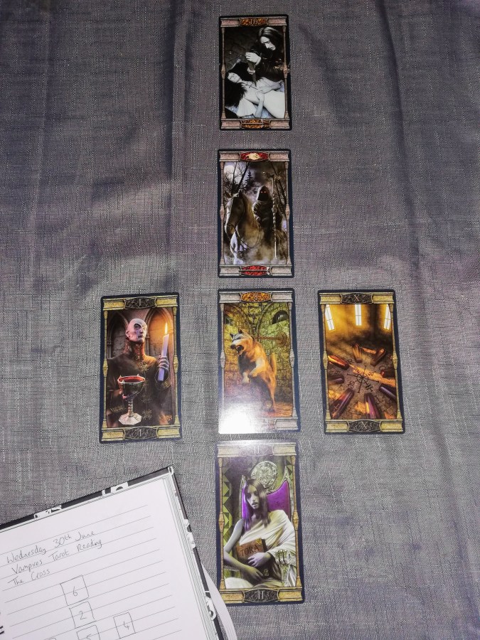 Image of Vampires Tarot of the Eternal Night Tarot cards on a grey cloth with a Tarot notebook nearby. June Tarot Reading by professional Tarot reader Catherine Green of SpookyMrsGreen.com pagan lifestyle blog.