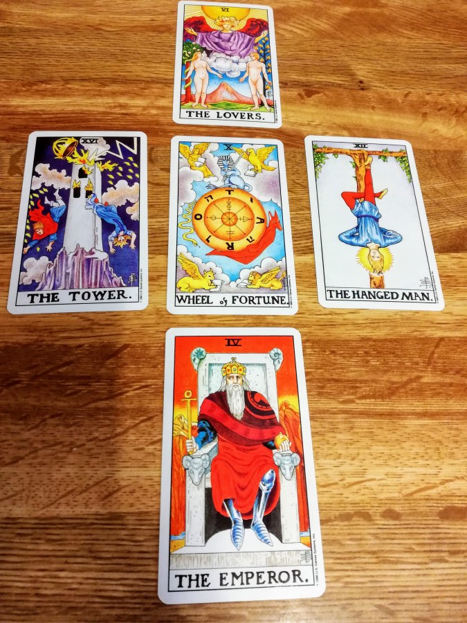 Image of Universal Rider Waite-Smith Tarot cards on a wooden table. September Tarot Reading by professional Tarot reader Catherine Green of SpookyMrsGreen.com pagan lifestyle blog.