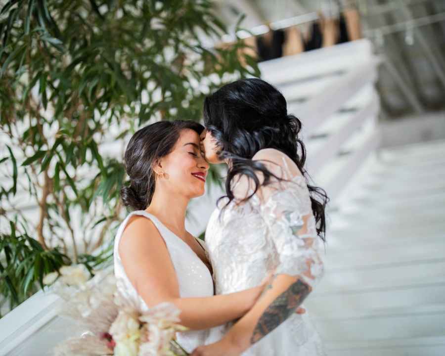 Two brides kissing each other on their wedding day. Photo featured at SpookyMrsGreen.com mindful parenting and modern pagan lifestyle blog.