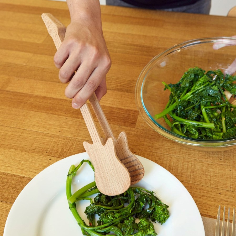Photo of a person using tongs to serve salad on a dinner table. Rockin Guitar Tongs from Kikkerland. Affiliated with SpookyMrsGreen.com mindful parenting and modern pagan lifestyle blog.
