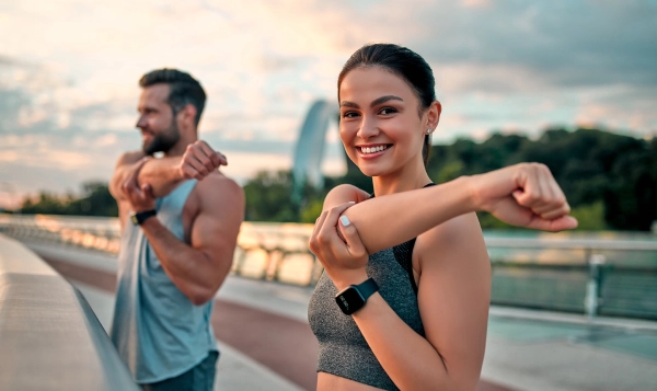Image of a man and a woman doing stretching exercises to warm up before a fitness workout. WeightWorld affiliated with SpookyMrsGreen.com mindful parenting and modern pagan lifestyle blog.