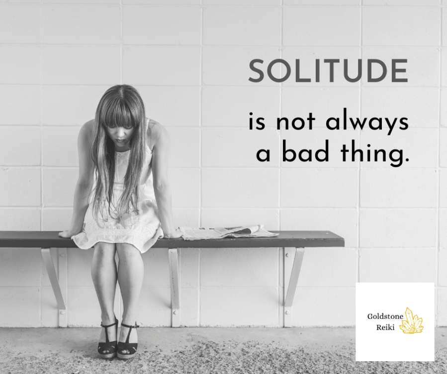 Black and white image of a woman wearing a white dress sitting on a bench look down at her feet. Text reads, “Solitude is not always a bad thing. Goldstone Reiki.” Shared by Catherine Green, Reiki Master Practitioner at Goldstone Reiki and SpookyMrsGreen.com.