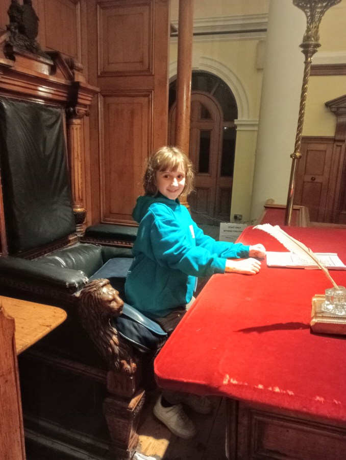 Image of a child sitting in the judge's chair of a Victorian court room at the National Justice Museum in Nottingham image credit Catherine Green at SpookyMrsGreen.com.