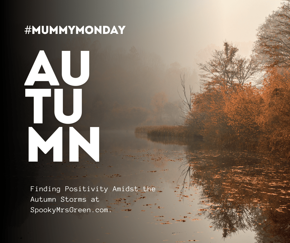 Aesthetic image of autumn trees on a dull day with a lake or river and misty sky. Text reads, “Finding Positivity Amidst the Autumn Storms at SpookyMrsGreen.com.”
