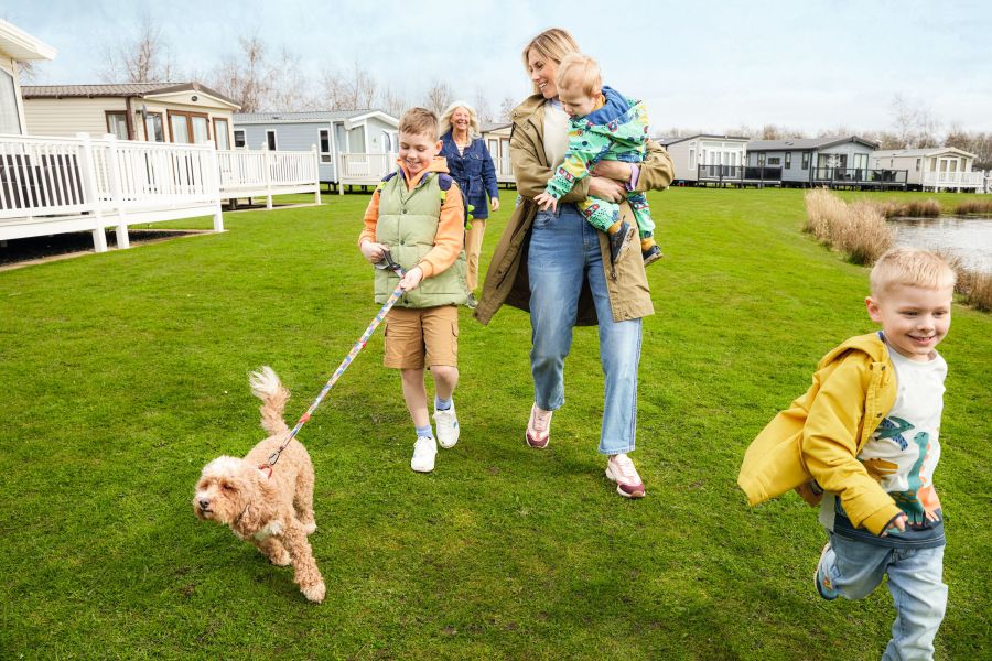 Colourful photo of a mum and her children walking a dog in a caravan park. Image provided by Haven Ultimate Family Weekends affiliated with SpookyMrsGreen.com mindful parenting and modern pagan lifestyle blog.
