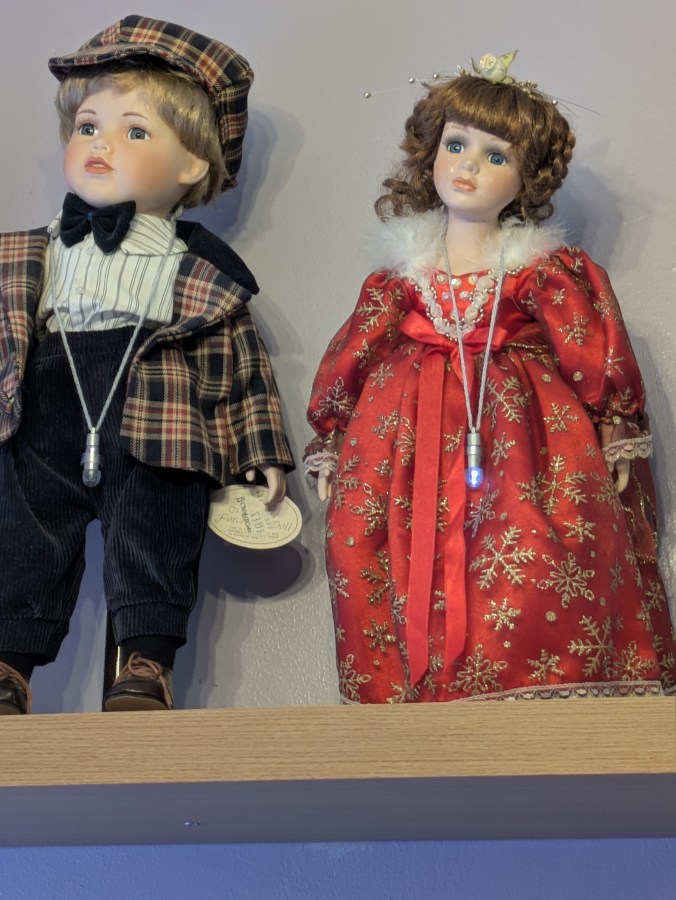 Image of haunted dolls on a shelf with lights flashing EMF activity Rempod activity paranormal investigation